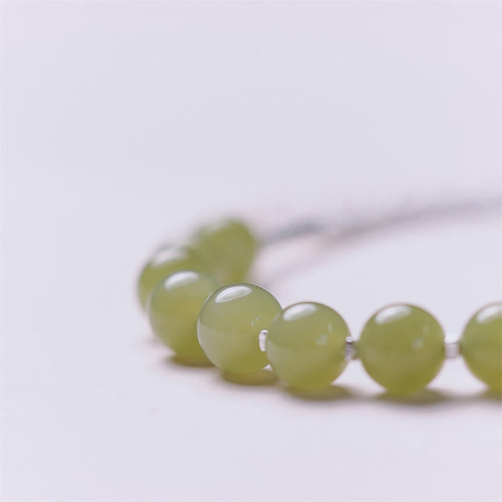 Grünes Jade Armband mit glänzenden Perlen auf weißem Hintergrund elegant