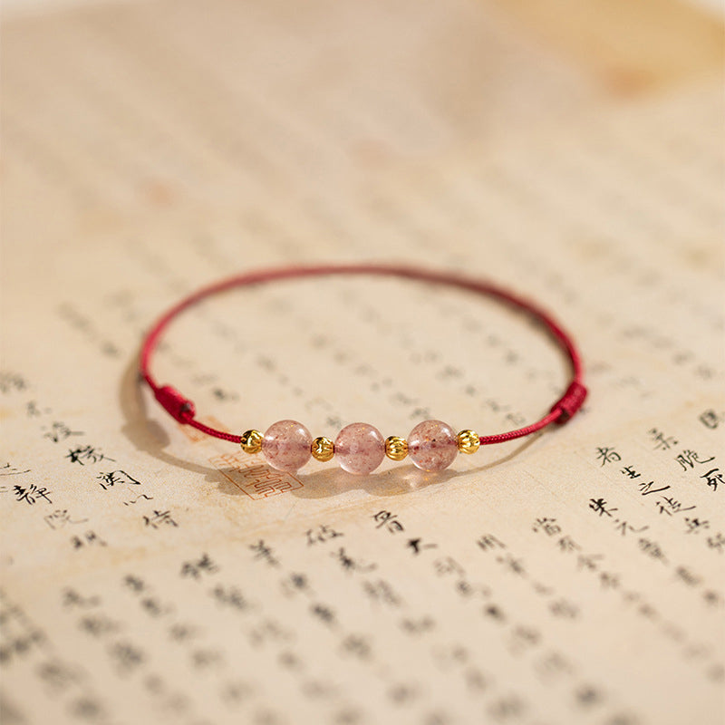Armband Erdbeerquarz auf Buch, rosa Perlen, rotes Textilband, Glück Lebensfreude