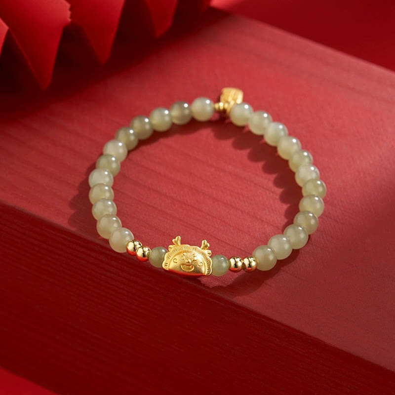 Jade Armband mit goldenem Lachsgott-Charm auf rotem Hintergrund elegantly