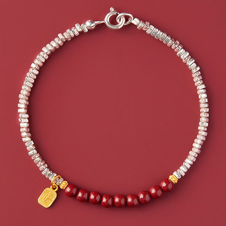 Silberarmband mit roten Perlen und goldenem Fu-Zeichen Anhänger.
