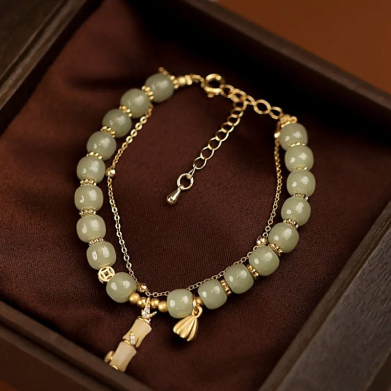 Jade Bambus Armband mit goldenen Perlen und Anhängern elegant.