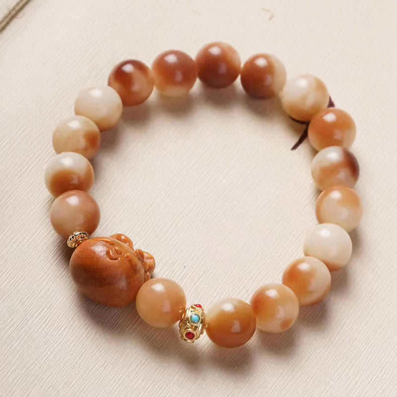 Bodhi Armband mit braunen Perlen und goldenen Verzierungen elastisch.