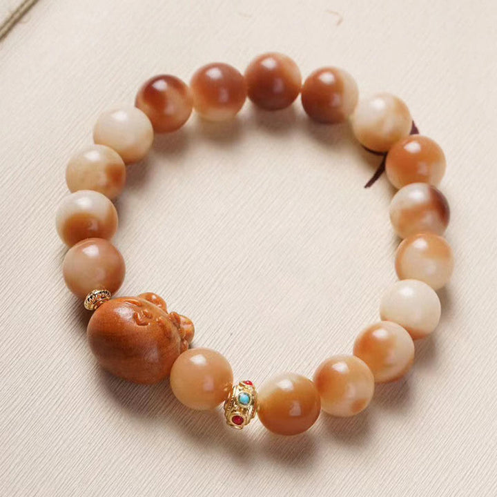 Bodhi Armband mit braunen Perlen und goldenen Verzierungen elastisch.