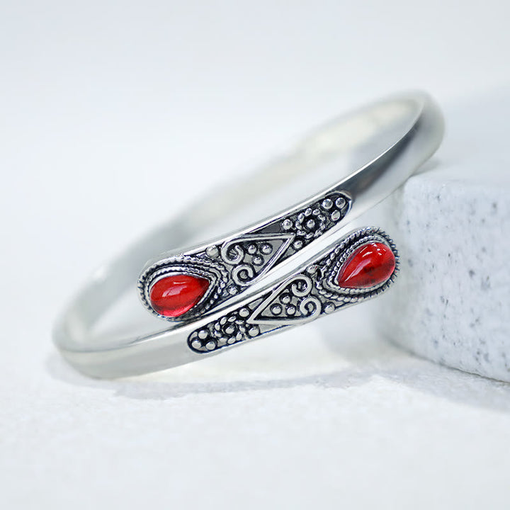 Silbernes Armband mit roten Steinen auf Marmor Nahaufnahme Schmuck