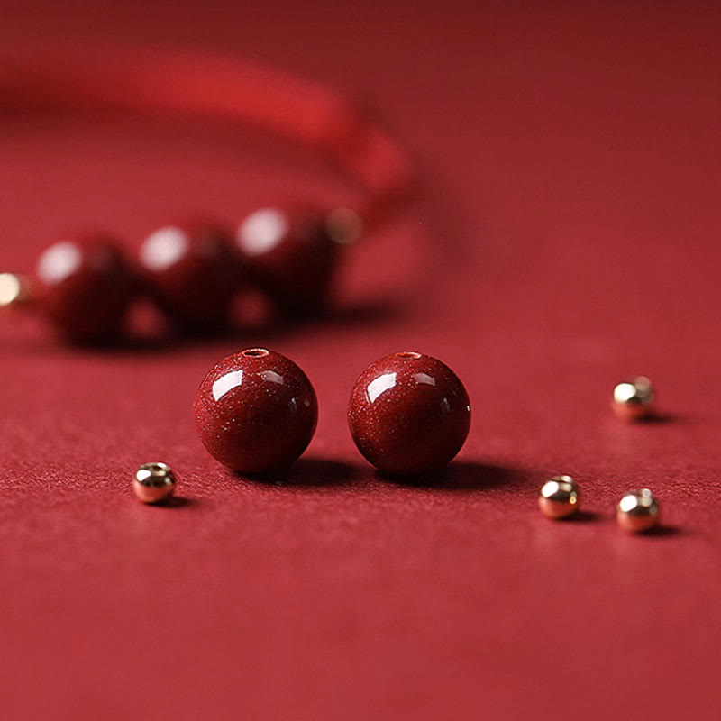 Armband Zinnober – Glück & Segen rote Perlen Flachaufnahme Goldakzente