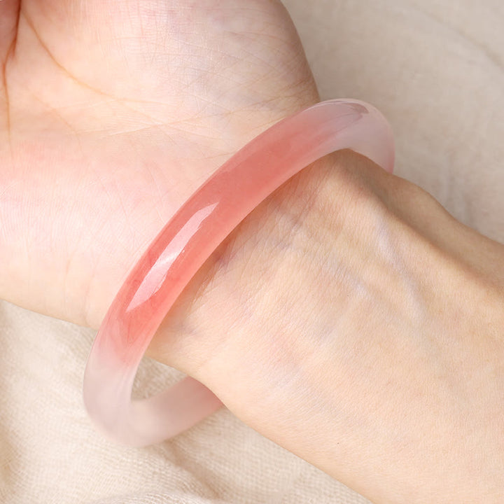 Rosafarbener Jade Armreif am Handgelenk getragen, poliert glänzend Armband