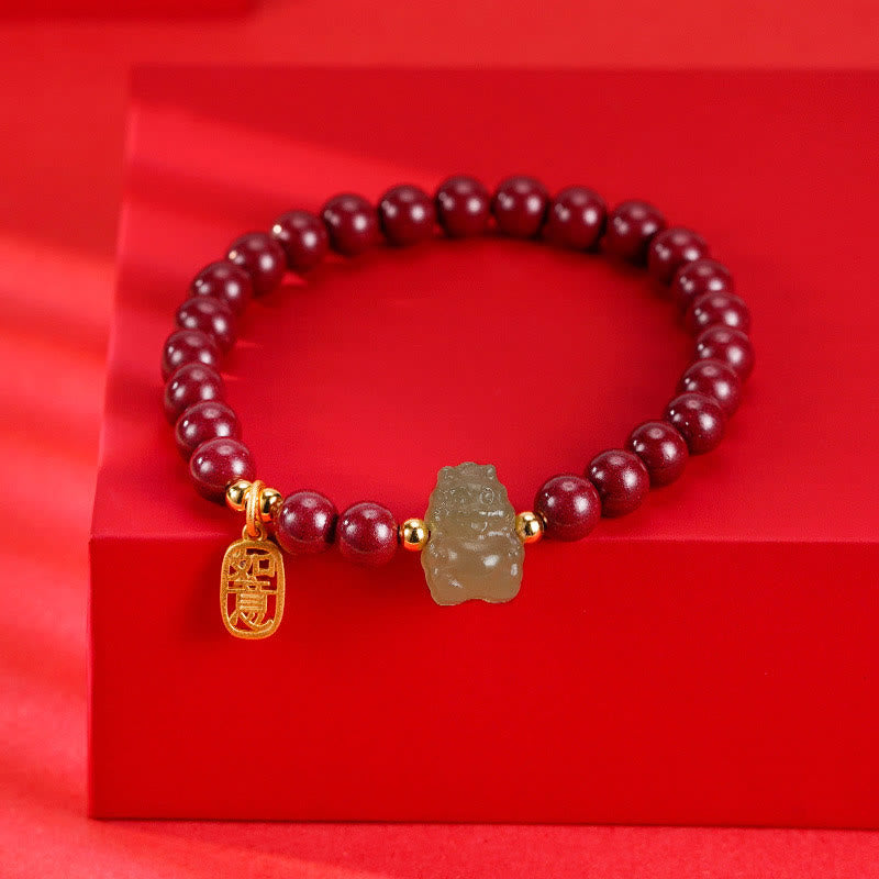 Granatrot Armband mit Jade-Anhänger und goldenem Fu-Zeichen Charm.