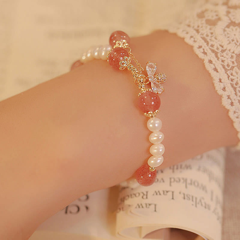 Armband Erdbeerquarz Perle mit goldenen Blütenakzenten elegant getragen