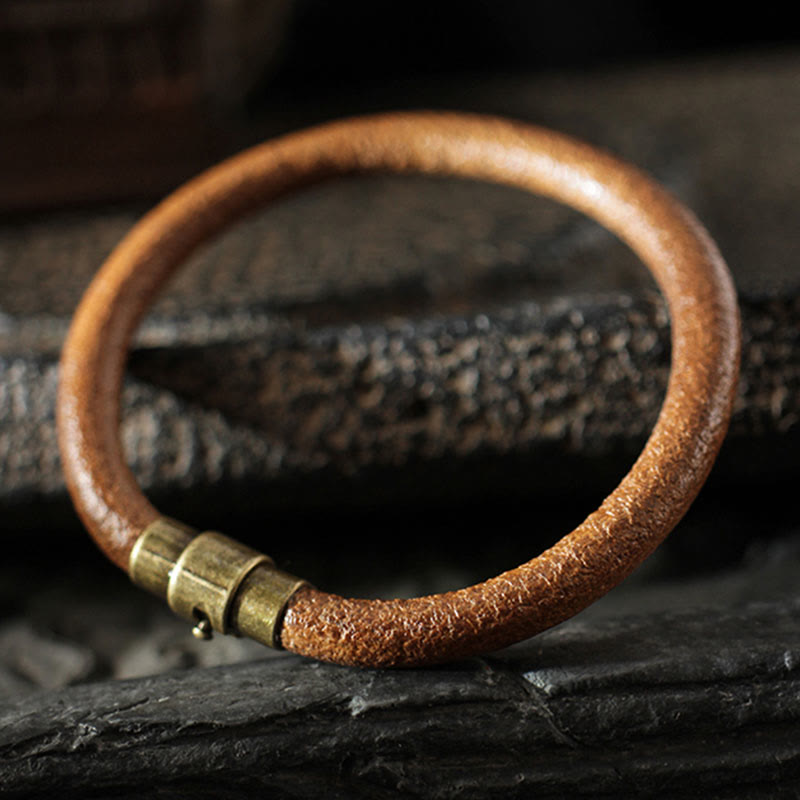 Kupfer Armband mit Messingakzenten auf dunklem Naturstein Hintergrund.