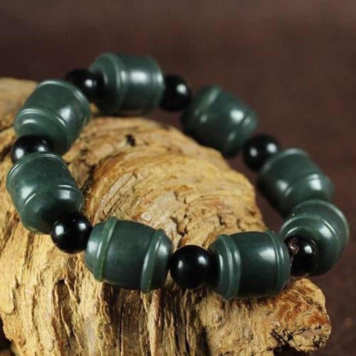 Armband Cyan Jade mit schwarzen Perlen auf Holz Natur.
