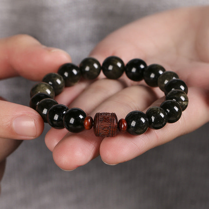 Schwarzes Obsidian Armband mit Om Mani Padme Hum Holzperle getragen