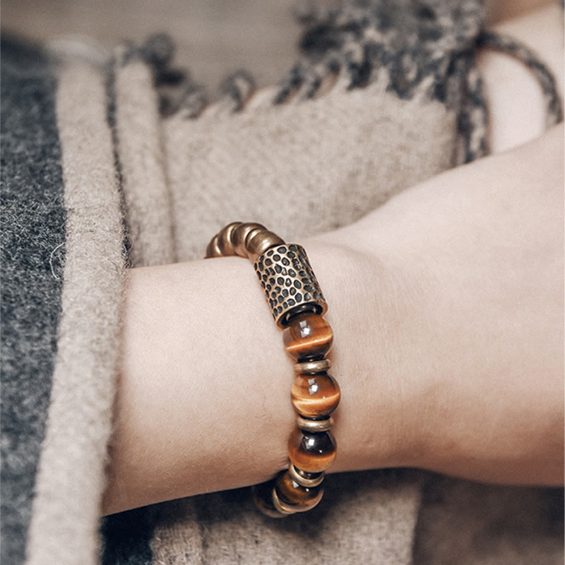 Armband Tigerauge Kupfer am Handgelenk mit braunen Perlen elegant.