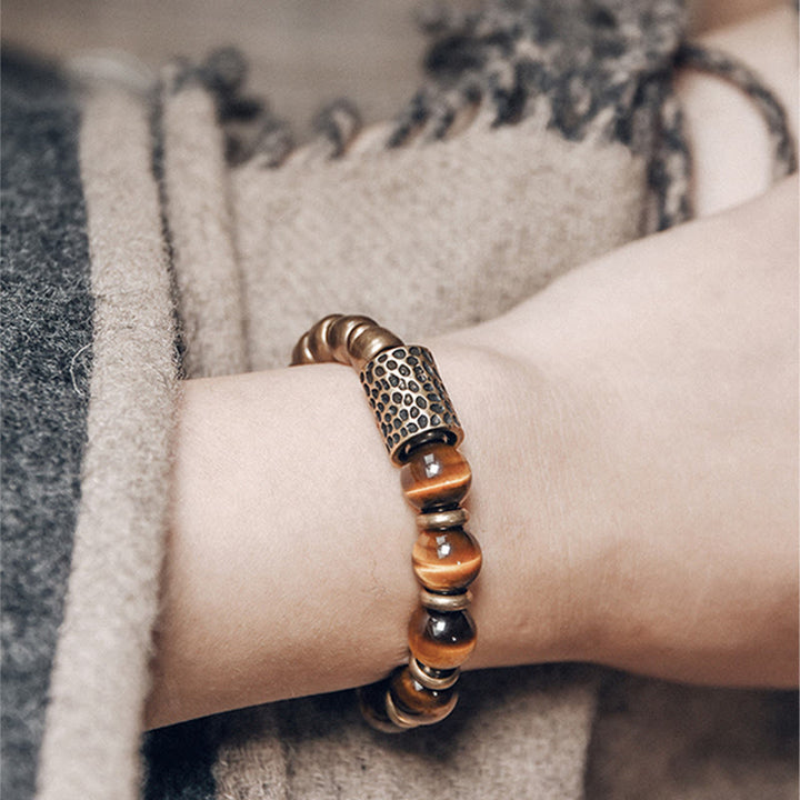 Armband Tigerauge Kupfer am Handgelenk mit braunen Perlen elegant.