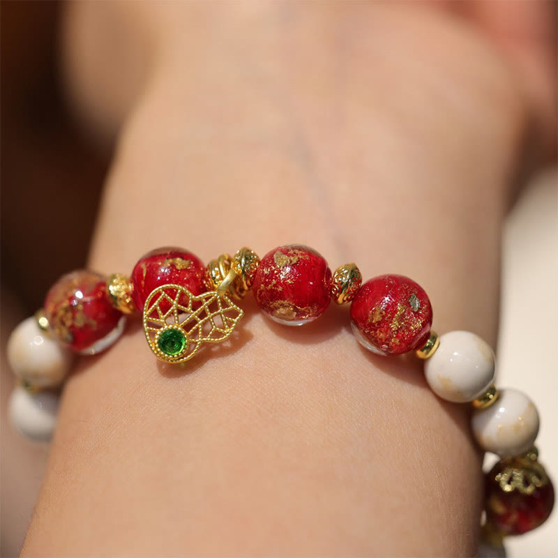 Armband Kürbis Wohlstand Glück rote Perlen goldene Akzente Handgelenk getragen