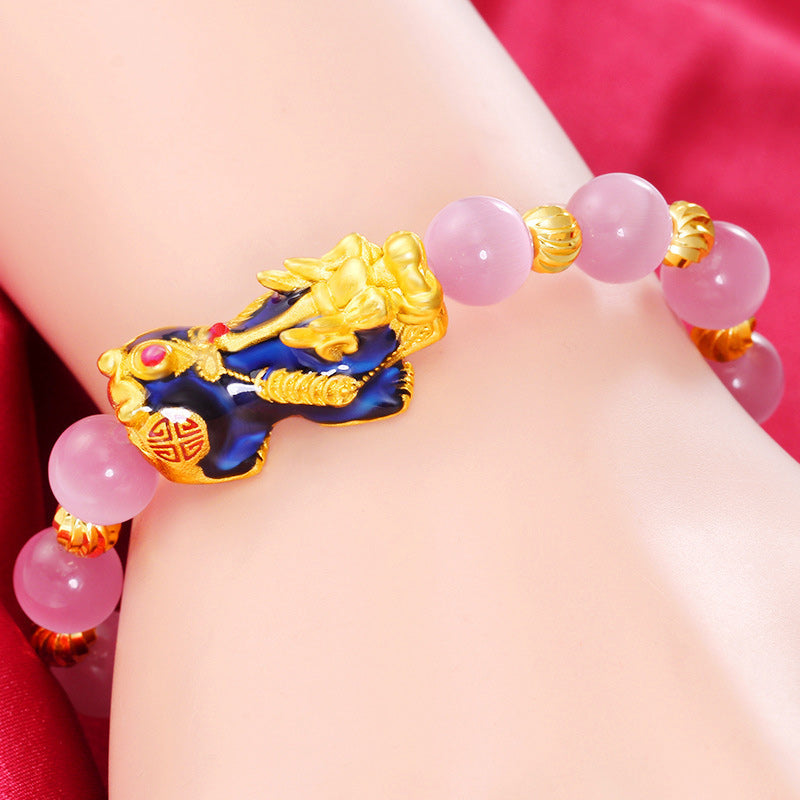 Armband Pixiu – Glück mit rosafarbenem Stein am Handgelenk getragen, vergoldetes Design