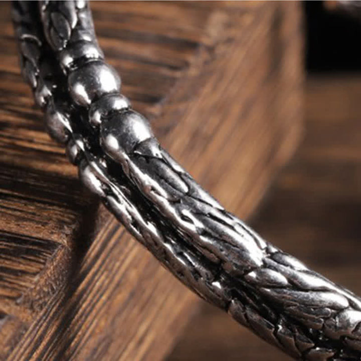 Silbernes Drachen-Armband auf Holzoberfläche, elegantes Design