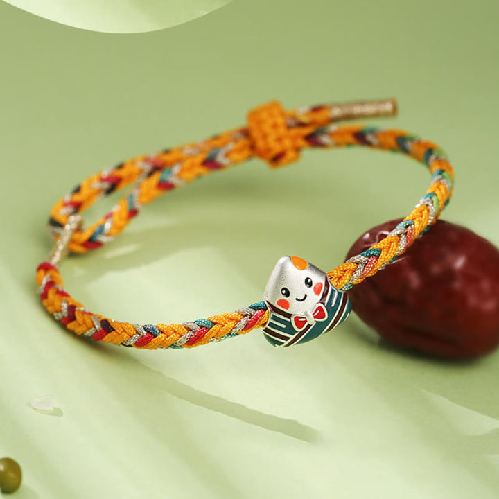 Buntes Armband mit Matroschka-Charm auf grünem Hintergrund elegant.