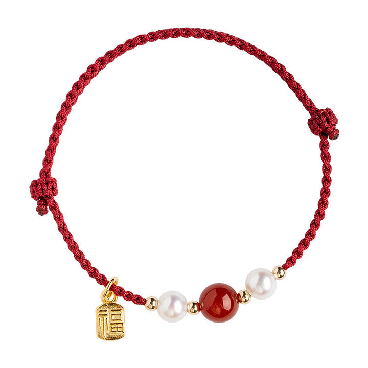 Rotes Armband mit Perlen, Achat und goldenem Fu-Zeichen Anhänger.