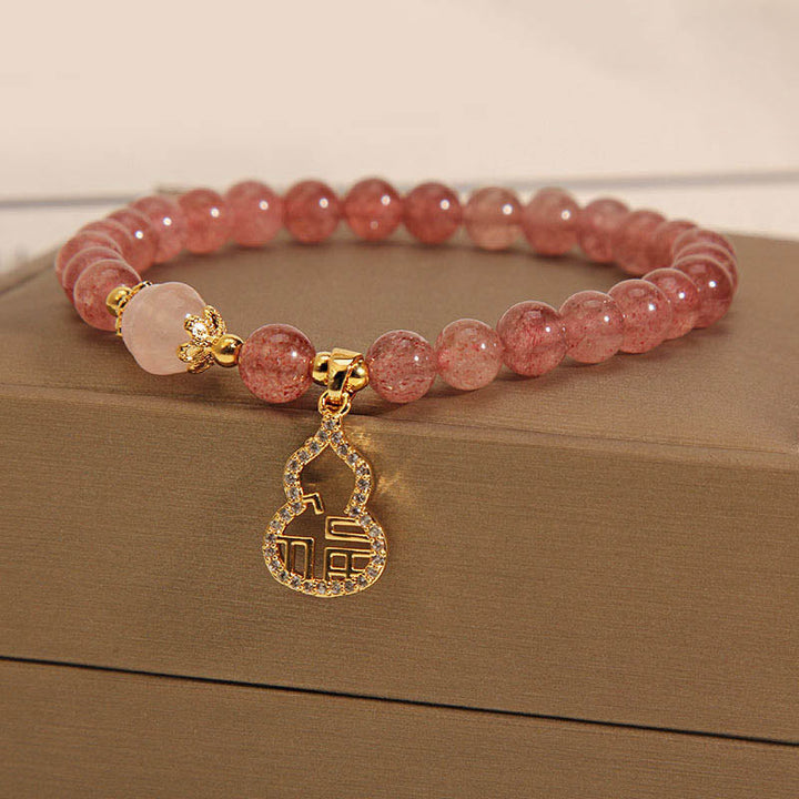Armband Erdbeerquarz Fu-Zeichen rosé Perlen elegantes Accessoire Handgelenk.