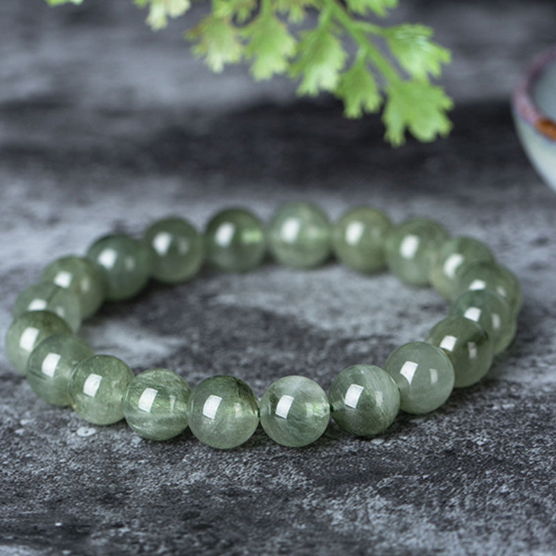 Grünes Kristall Armband Wohlstand & Segen auf Stein flach liegend