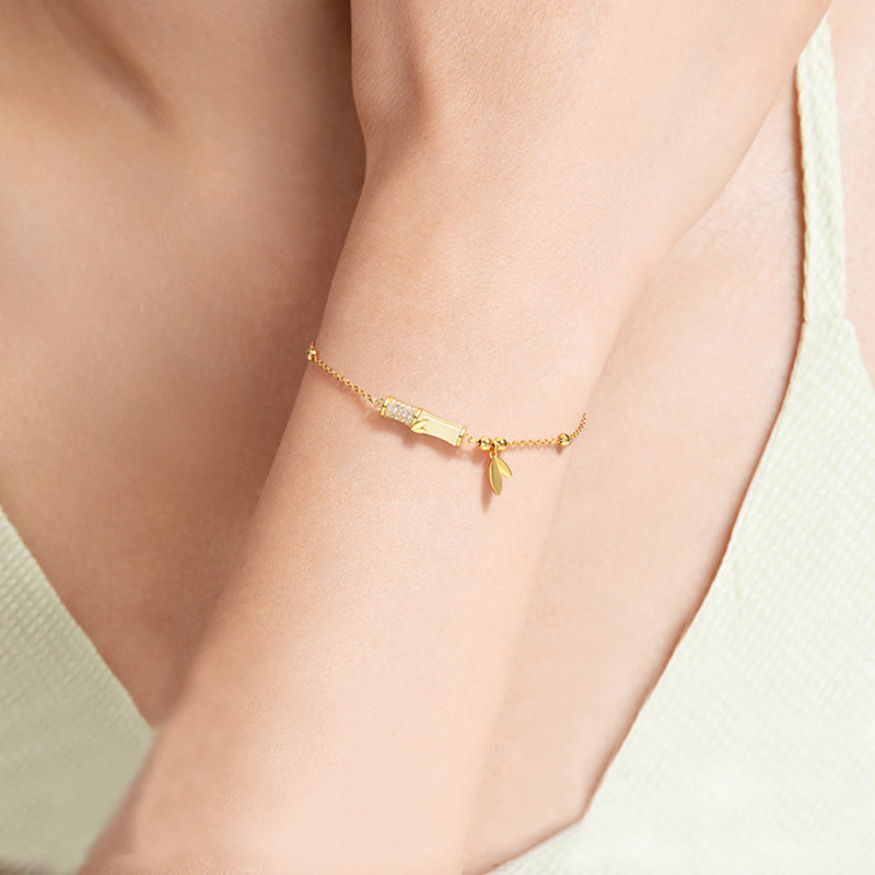 Goldenes Armband mit Plakette und Anhänger am Handgelenk getragen elegant