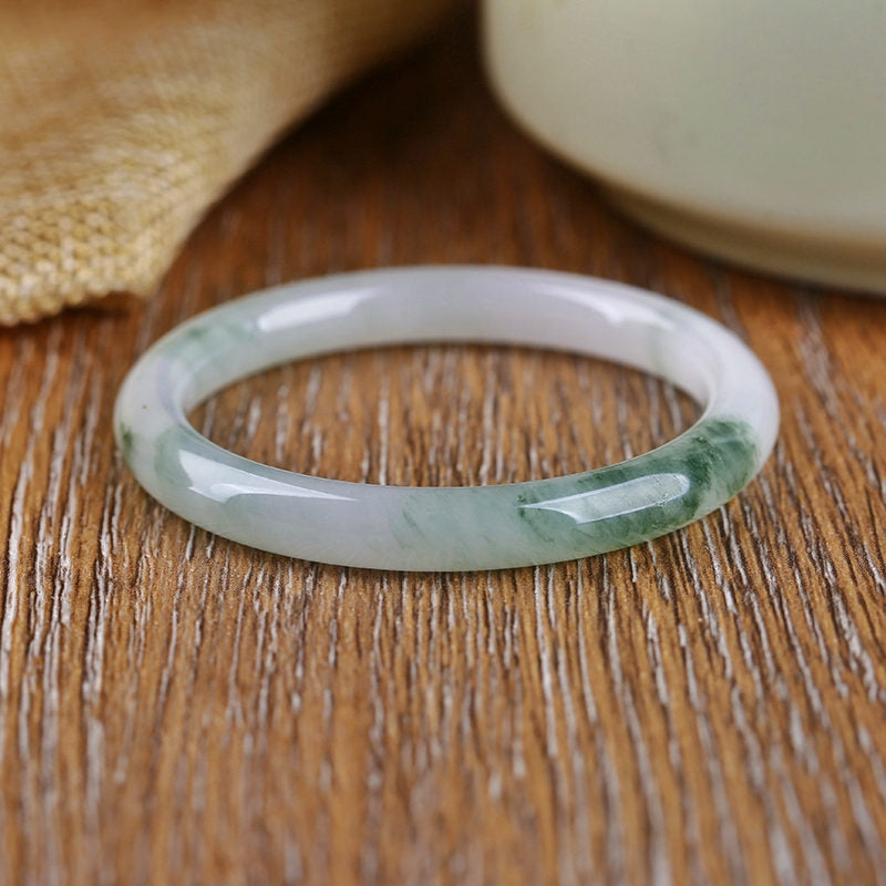 Jade Armband mit grünen Einschlüssen auf Holzoberfläche Schutz Fülle