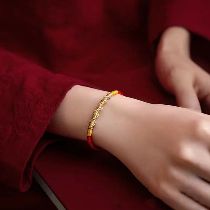 Rotes Armband mit goldenen Perlen am Handgelenk getragen elegant
