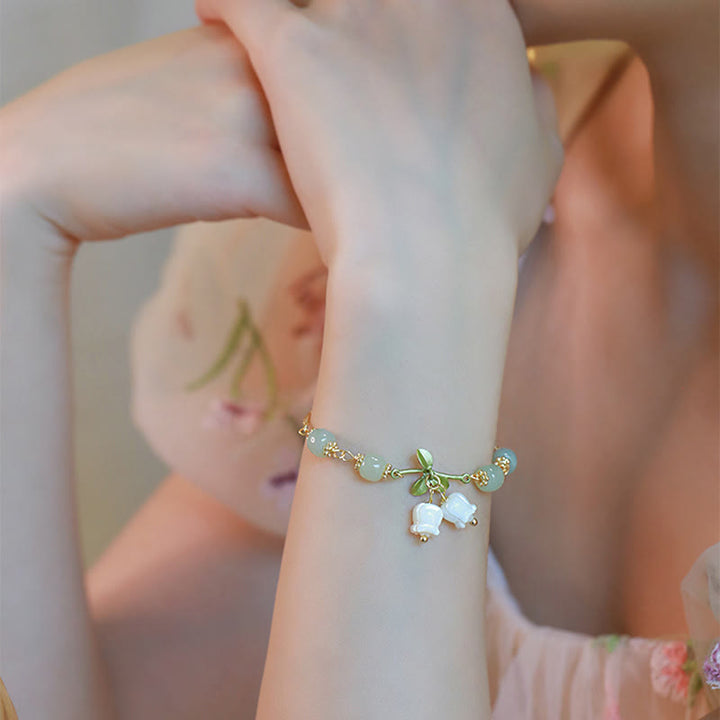 Armband Grüne Jade – Wohlstand mit weißen Perlen elegant am Handgelenk getragen