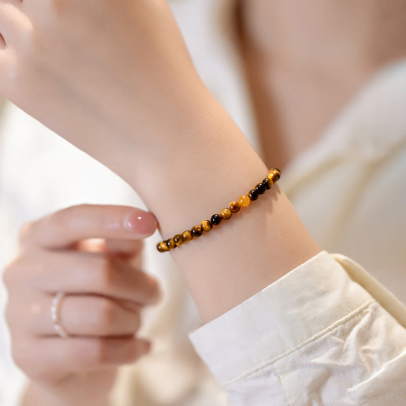 Tigerauge Armband am Handgelenk getragen, goldbraune Natursteine, elastisch, Schutz Mut