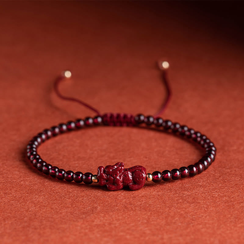 Rotes Granat Pixiu Armband mit Perlen auf Untergrund elegant.