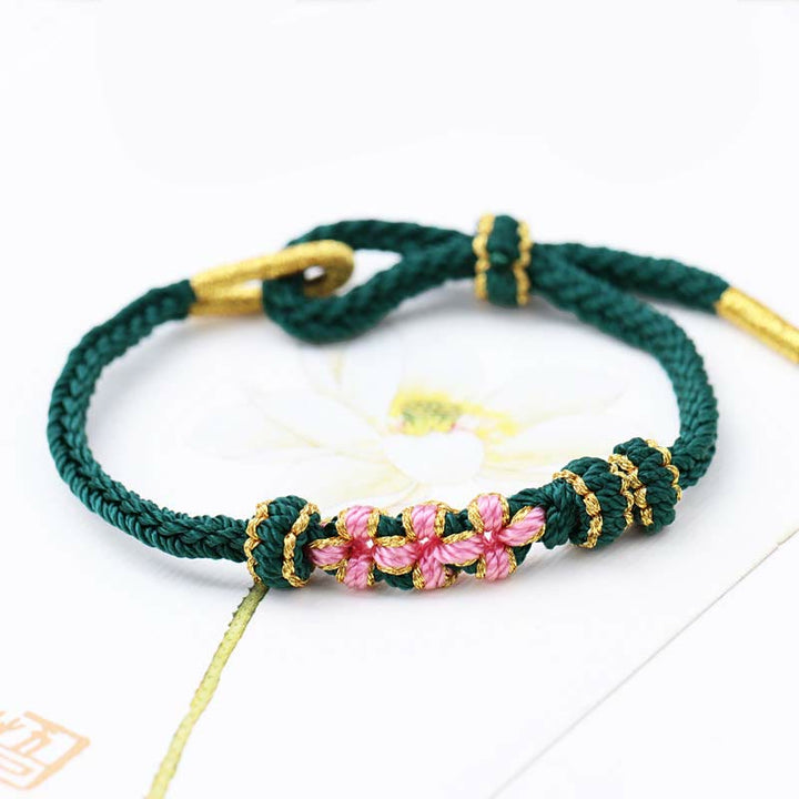 Armband Pfirsichblüte – Glück grünes Seil goldene Perlen rosa Blüten