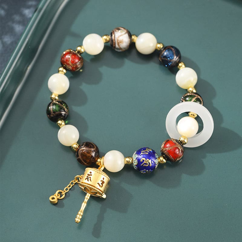 Armband Om Mani Padme Hum Sonnenstein mit weißen Perlen golden verziert.