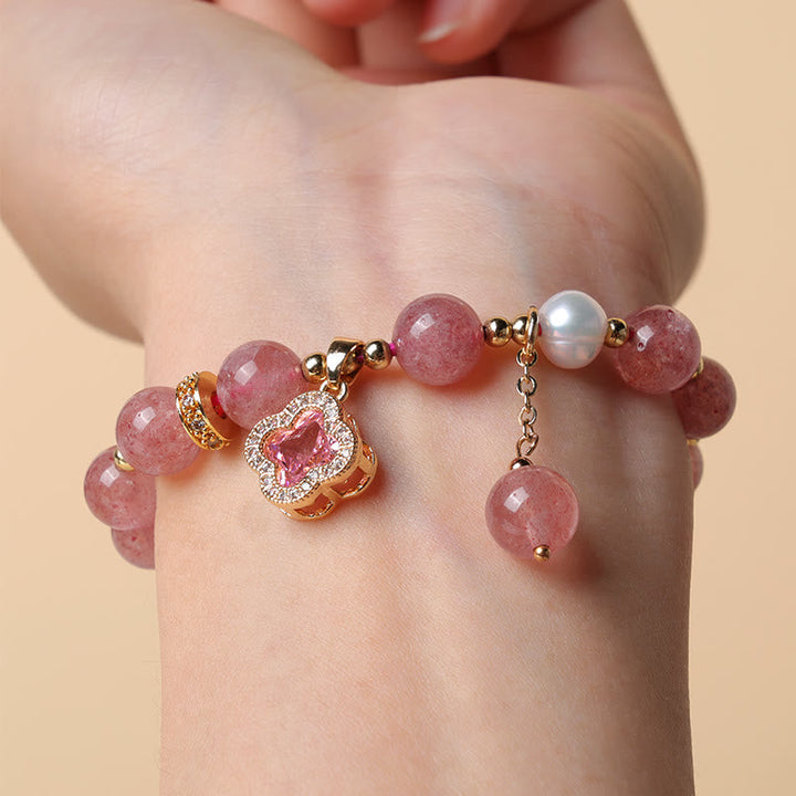 Erdbeerquarz Armband mit Perle und Kleeblatt Anhänger am Handgelenk getragen