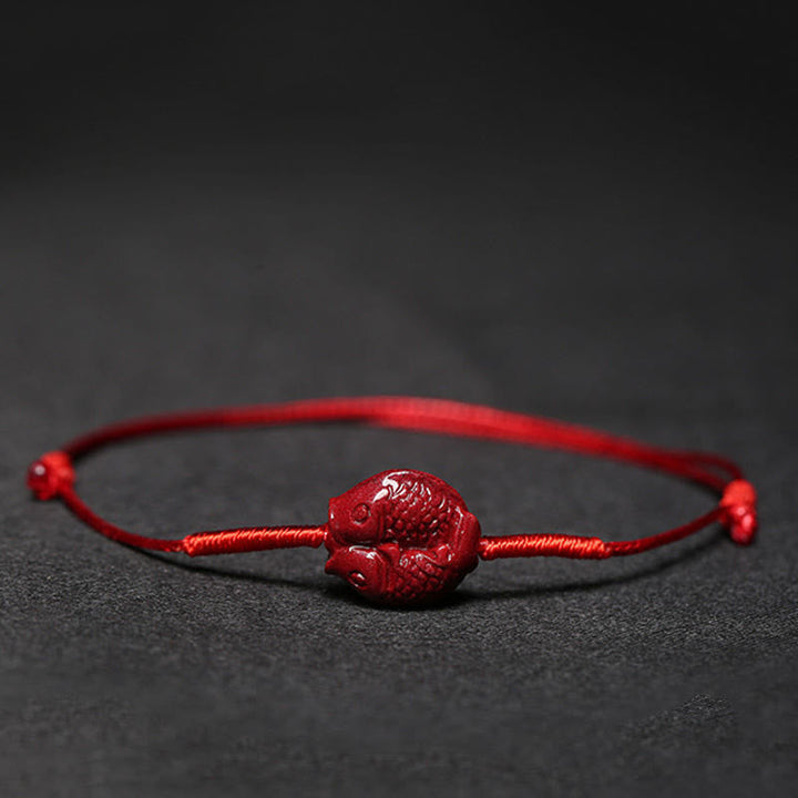 Rotes Armband Zinnober Koi Fisch Flachaufnahme dunkelgrauer Hintergrund Liebe Segen