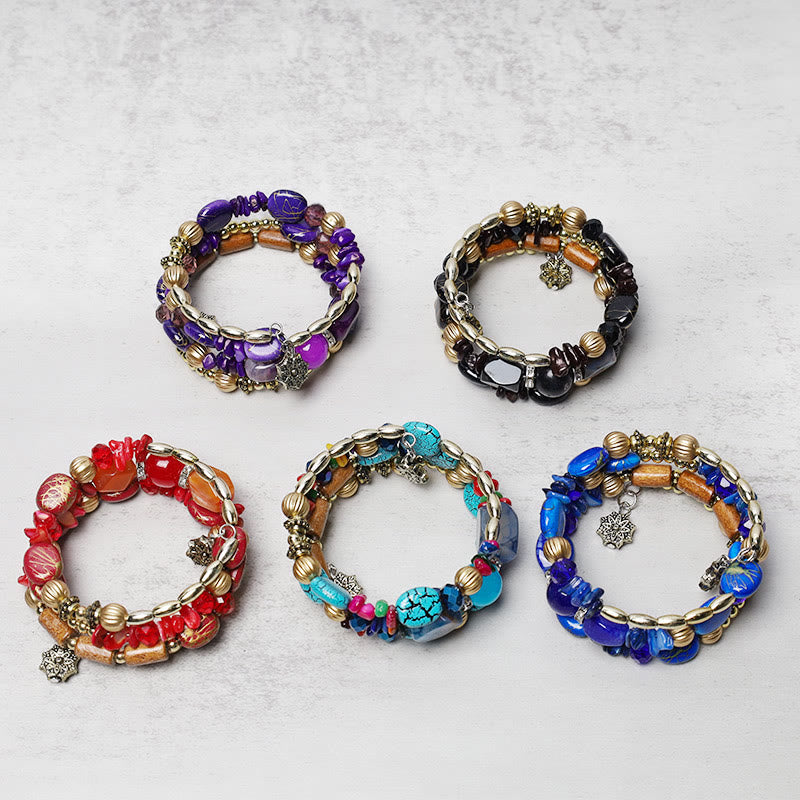 Fünf bunte Armbänder mit Perlen und Charm Flatlays auf grauem Hintergrund