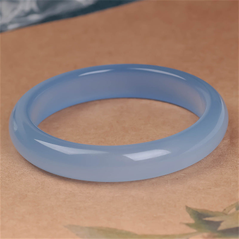 Hellblaubraunes Armband – Balance & Energie auf beigem Hintergrund elegant präsentiert.