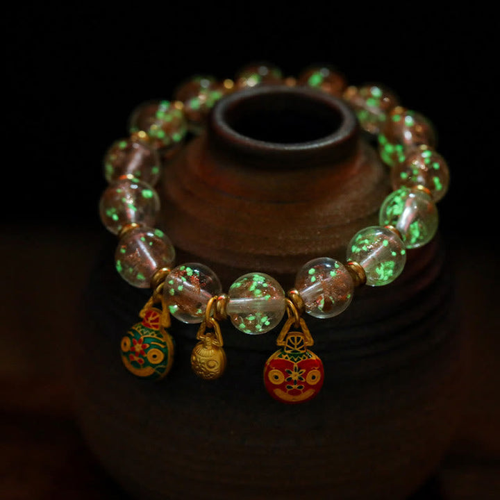 Armband mit grünen Perlen und roten Anhängern elegant präsentiert