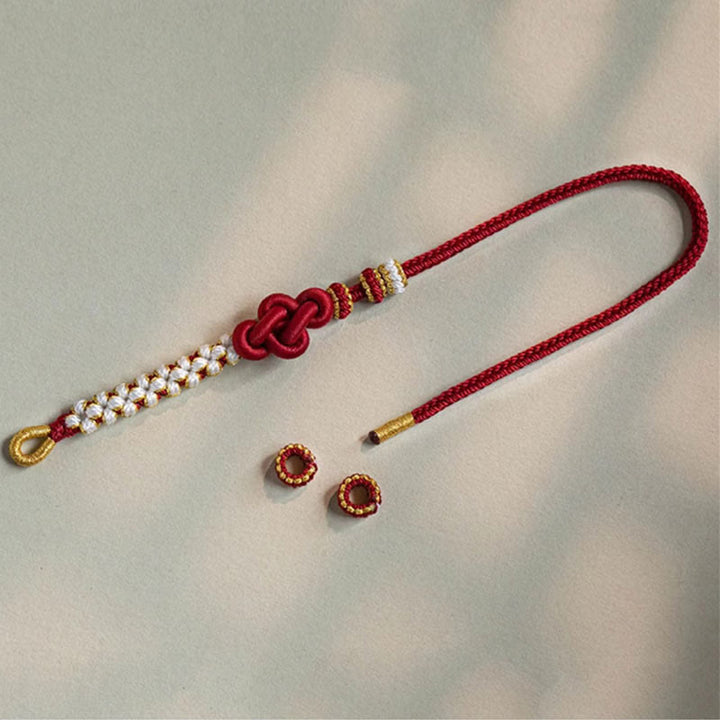 Rotes Armband Pfirsichblüte mit Perlen und goldenen Akzenten elegantly displayed.