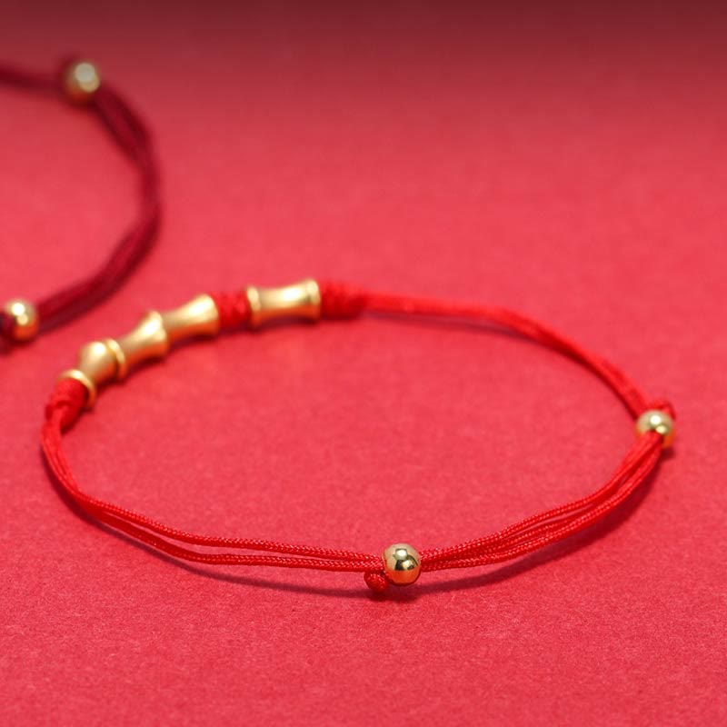 Rotes Seidenarmband mit goldenen Perlen elastisch verstellbar elegant.