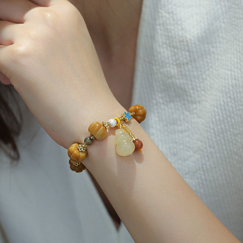 Jade Pixiu Armband mit Holzperlen und Anhängern am Handgelenk getragen