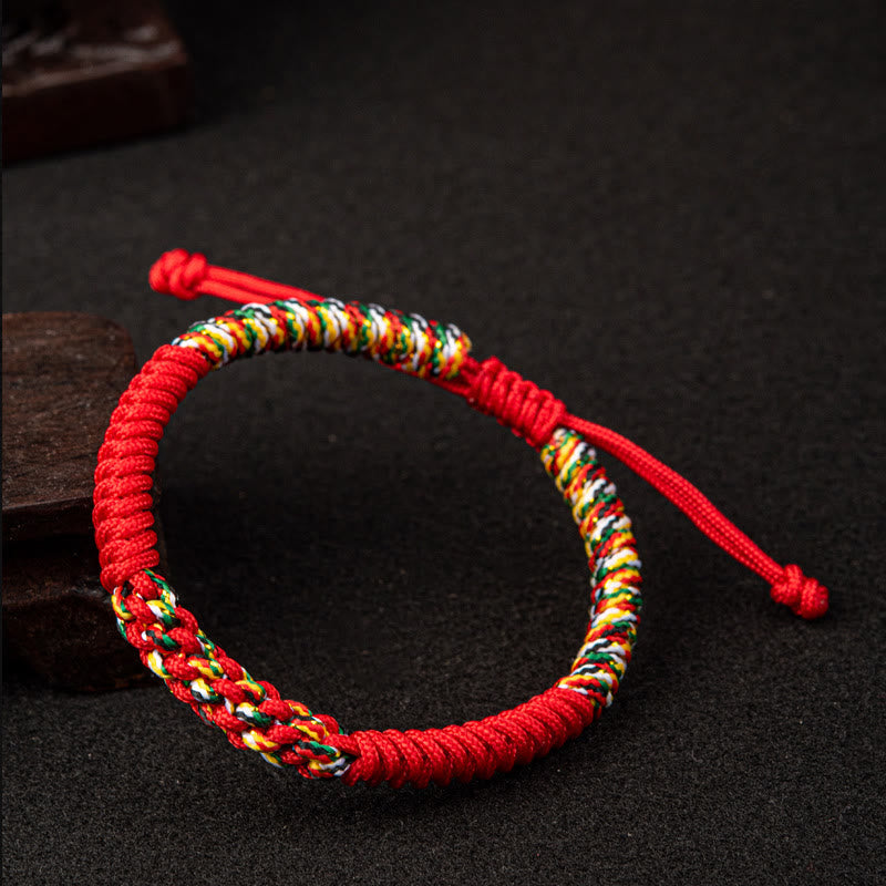 Rotes Seidenschnur Mala Armband mit bunten Perlen auf dunklem Hintergrund.