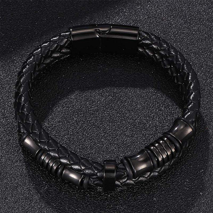 Schwarzes Leder Weave Armband mit Metallverschluss Glück auf grauem Untergrund