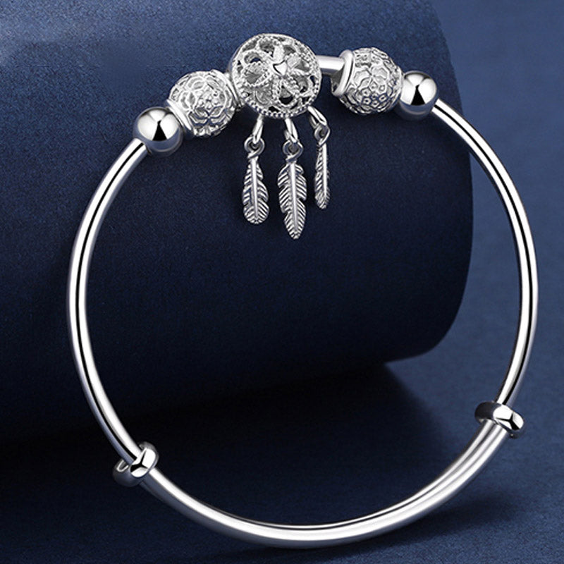Silbernes Armband mit Perlen und Federn Charm elegant.