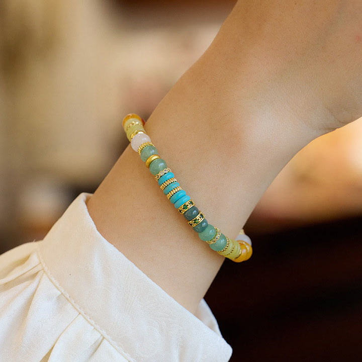 Armband mit Jade und goldfarbenen Perlen am Handgelenk getragen