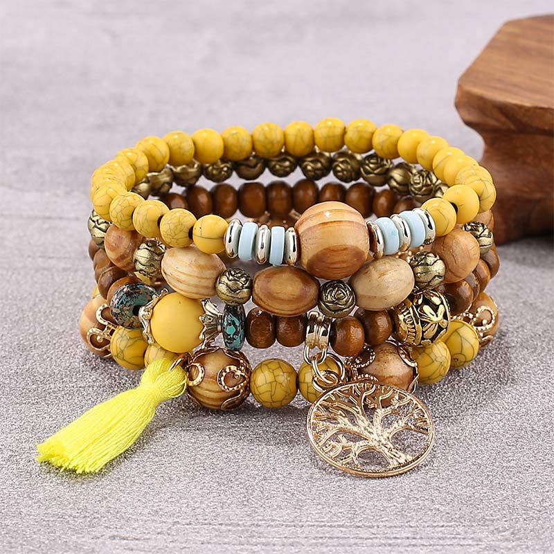 Armband – Heilung mit Holzperlen, Metallcharms und gelbem Quaste.