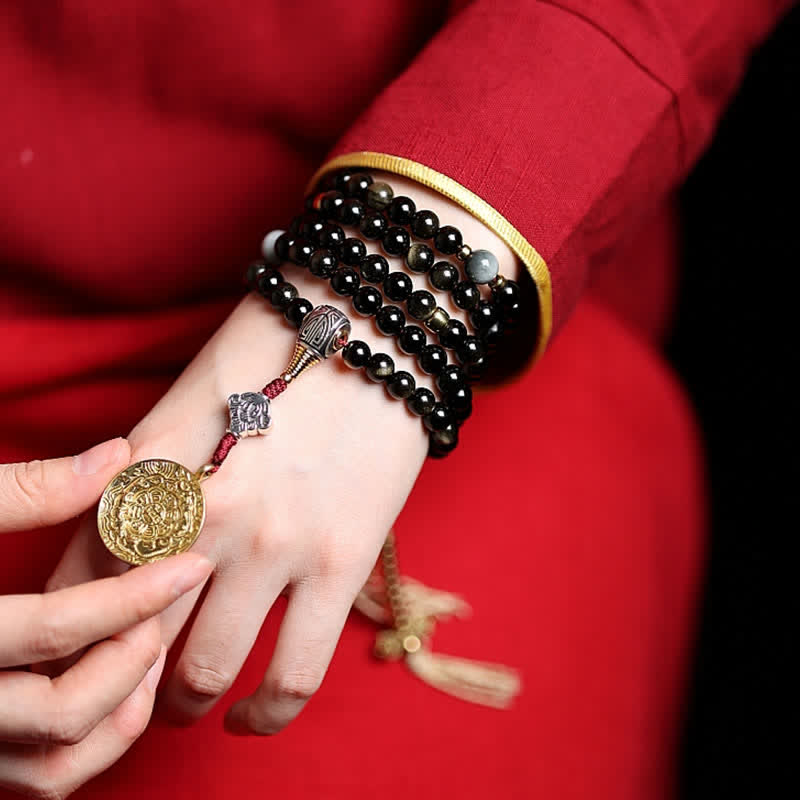 Schwarze Mala Obsidian Armband mit Goldmünze Anhänger elegant getragen