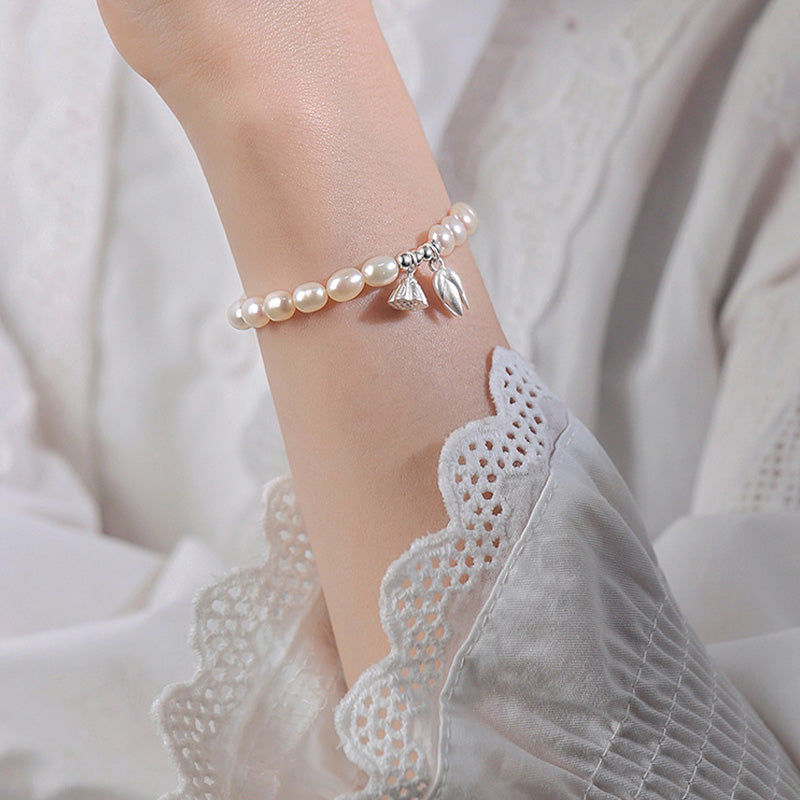 Perlenarmband 925 Silber mit Lotus-Anhänger elegant am Handgelenk getragen.