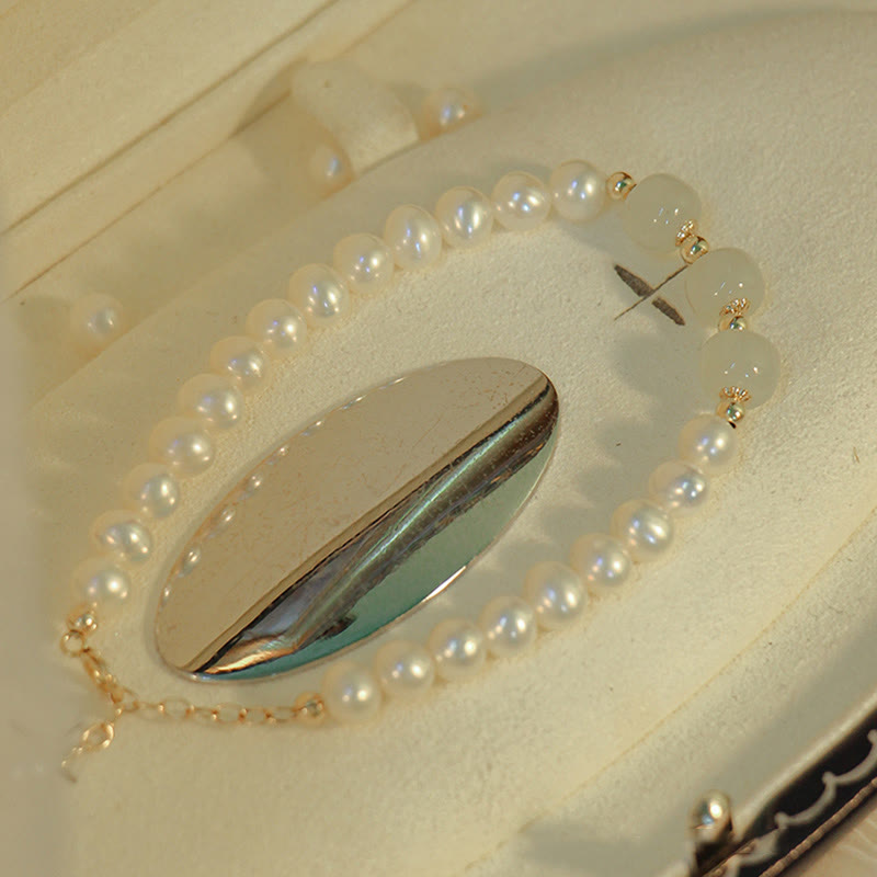 Armband Weiße Jade mit Perlen und Metallakzenten elegant präsentiert.