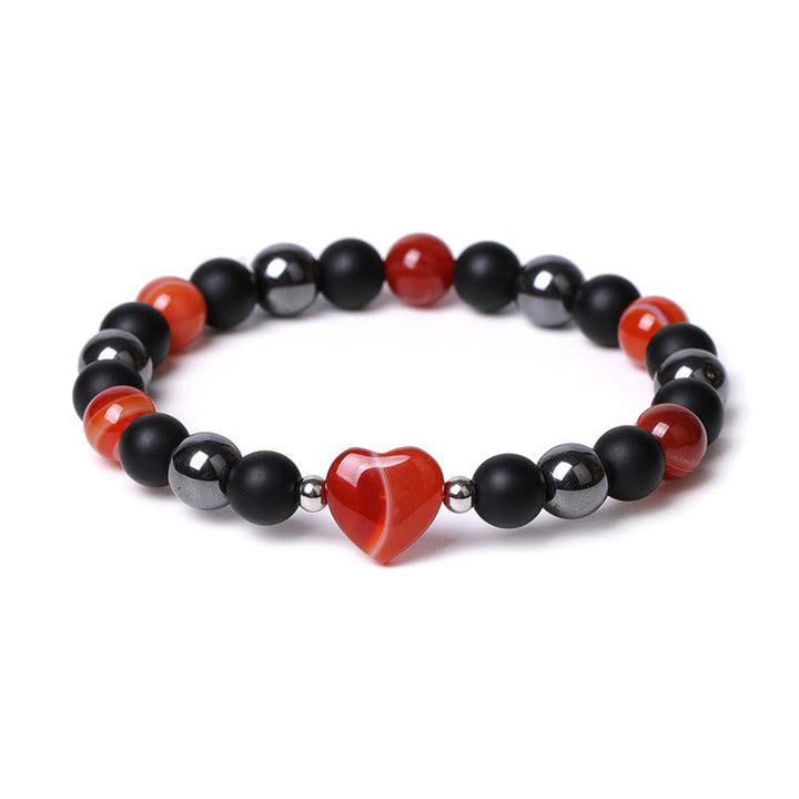 Armband Schwarzer Onyx Tigerauge mit rotem Herzanhänger elastisch getragen