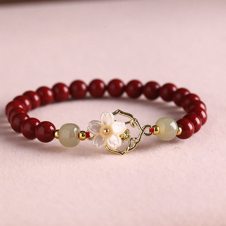 Armband Zinnober Jade – Segen mit goldenen Blütendetails eleganz